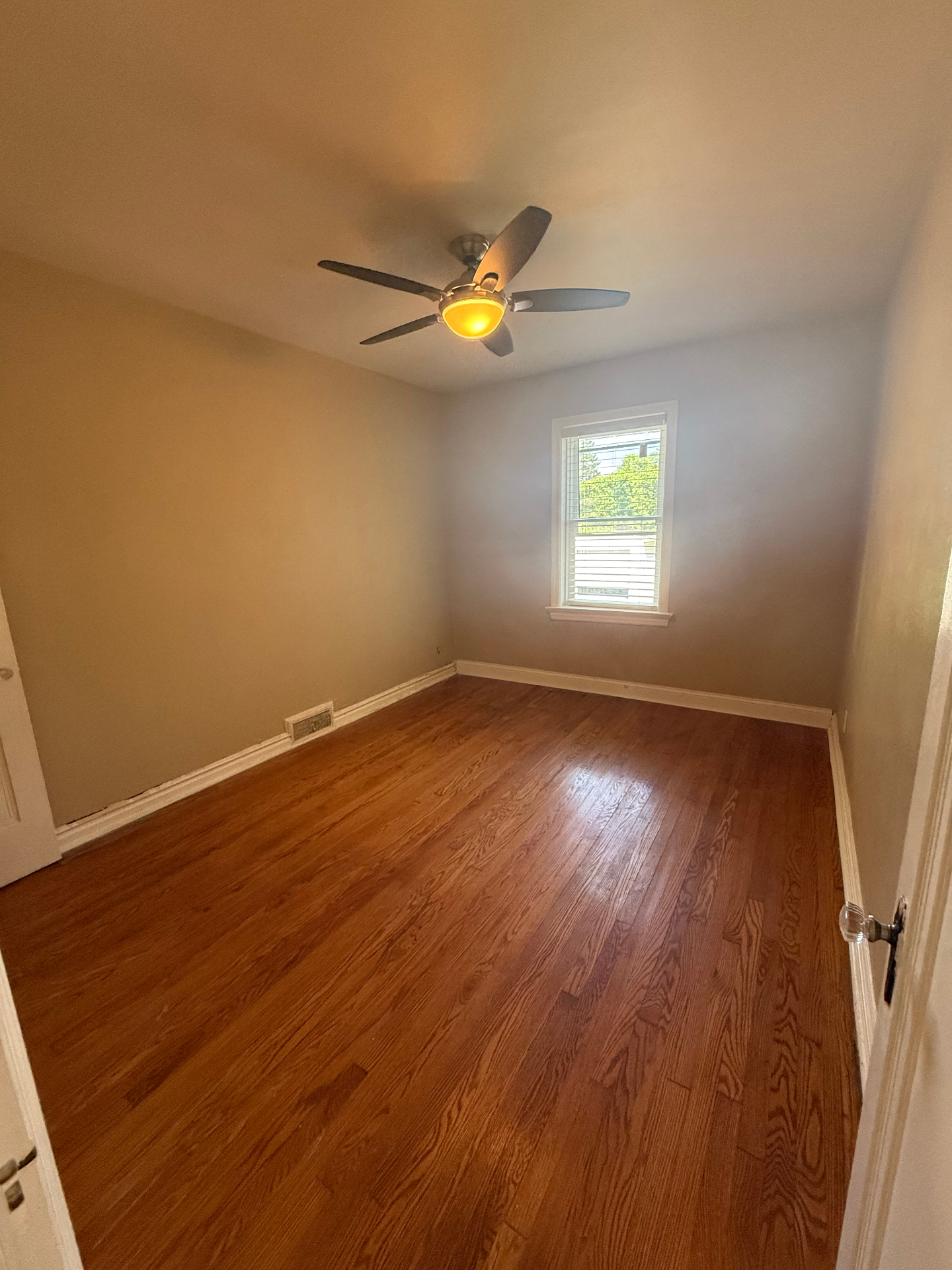Second bedroom with hardwood floors and window