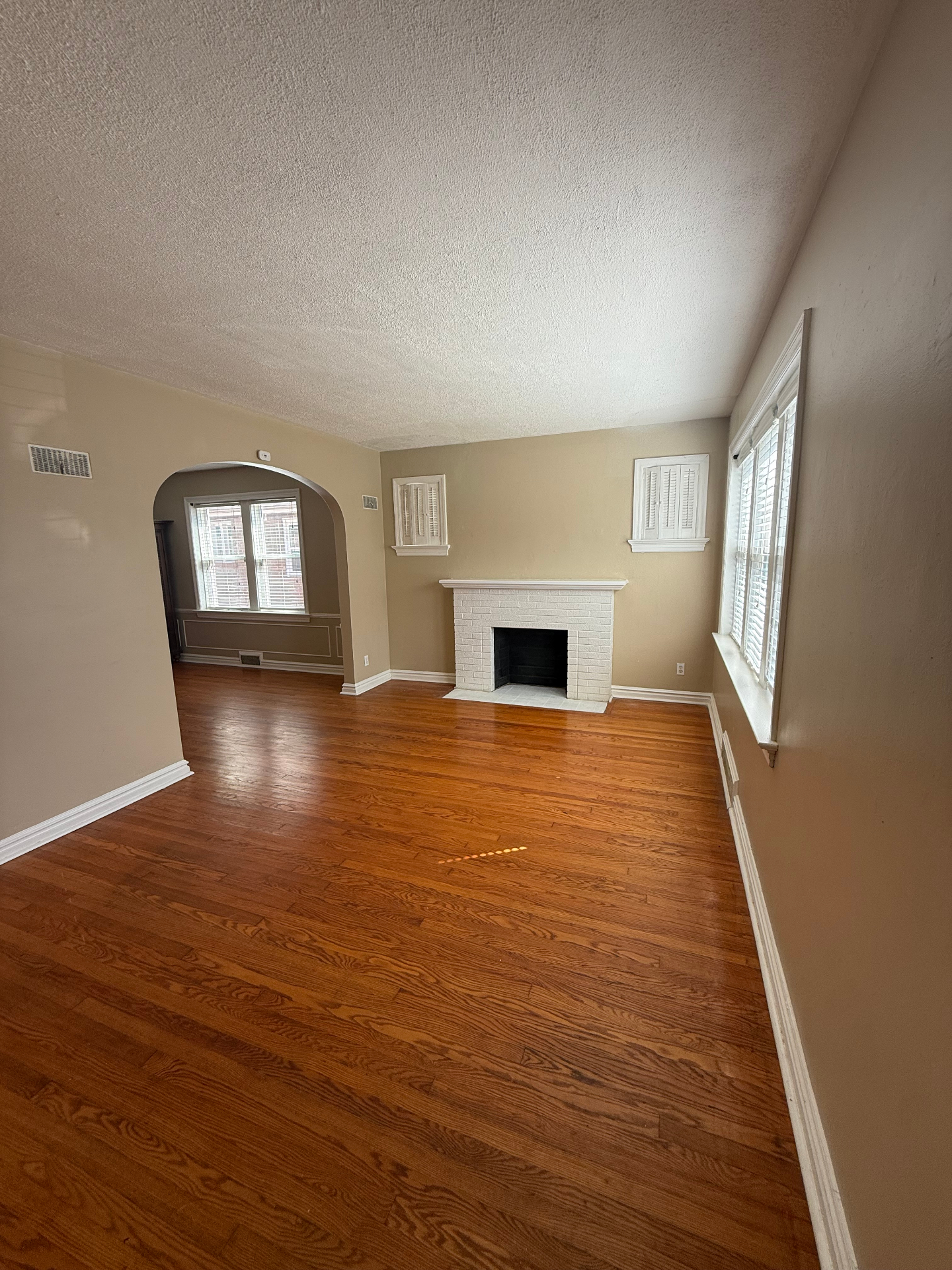Living room with hardwood floors and brick fireplace