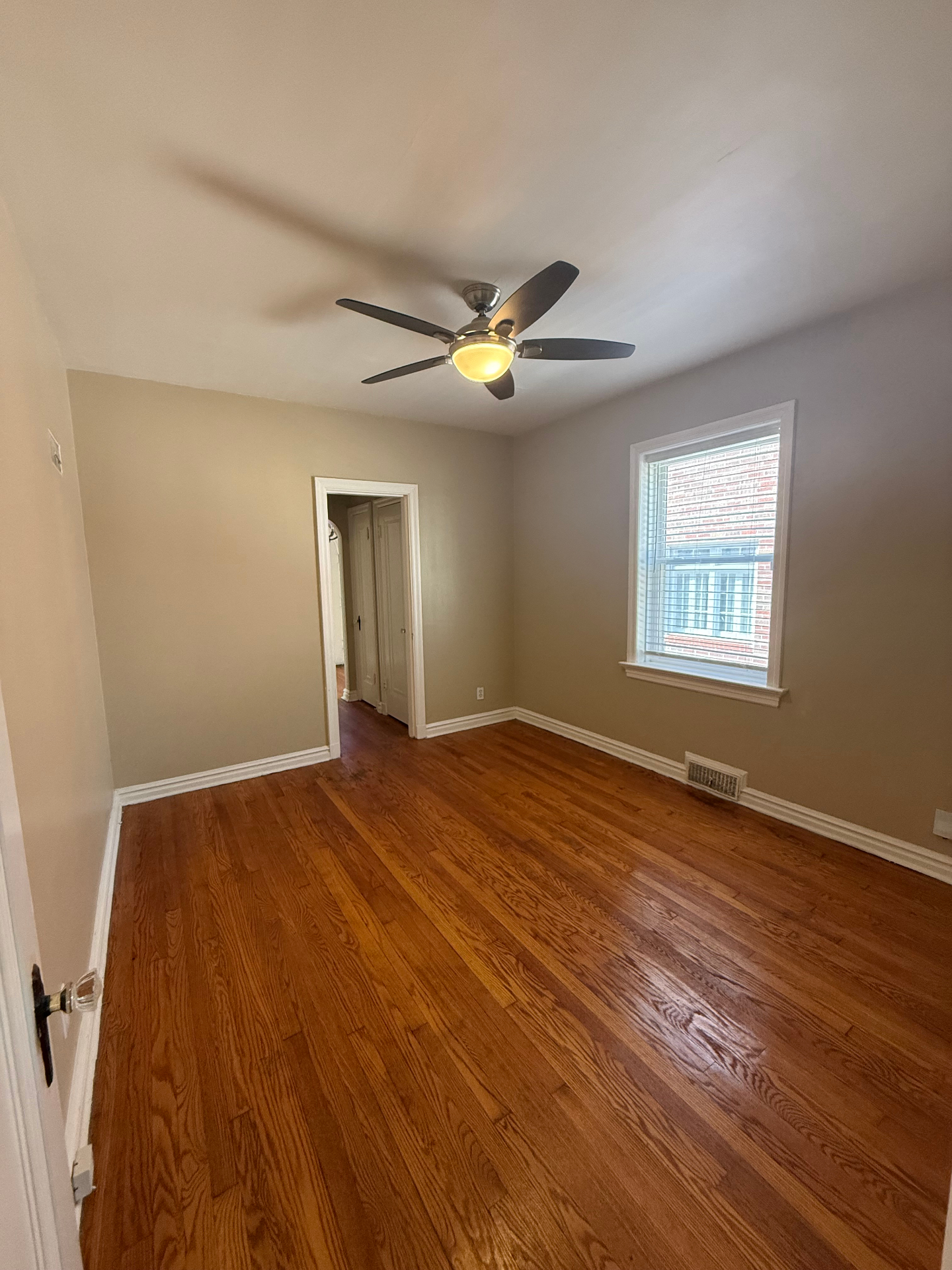 First bedroom with hardwood floors and ceiling fan